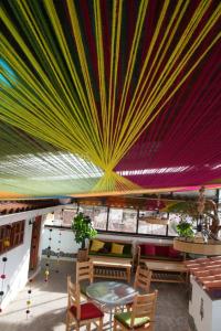 MATARA GREENS HOTEL في كوسكو: غرفة ذات سقف ملون وطاولات وكراسي