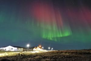 una imagen de la aurora boreal en el cielo en Pokój z prywatną łazienką i kuchnią z hot pot, en Keflavík
