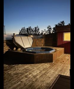 un bain à remous installé au-dessus d'une terrasse en bois dans l'établissement Pokój z prywatną łazienką i kuchnią z hot pot, à Keflavík