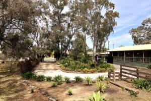 a garden in front of a building with a bench at Echuca Retreat Holiday House in Echuca