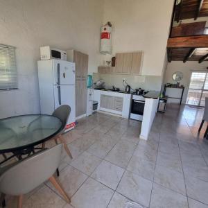 een keuken met een tafel en een witte koelkast bij La normita in Villa Anizacate