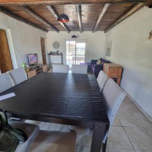 een eetkamer met een zwarte tafel en witte stoelen bij La normita in Villa Anizacate