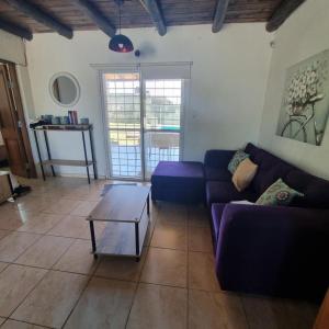 een woonkamer met een paarse bank en een tafel bij La normita in Villa Anizacate