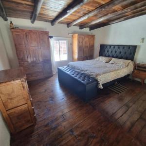 een slaapkamer met een bed en een houten vloer bij La normita in Villa Anizacate