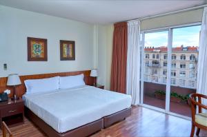 1 dormitorio con cama y ventana grande en Hotel Cityzen Guayaquil, en Guayaquil