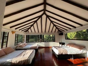 Habitación grande con 2 camas y ventanas. en CASA CAMPESTRE VILLA SANTANA, en Villa de Leyva