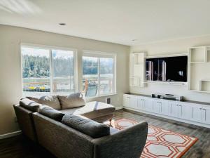 uma sala de estar com um sofá e uma televisão em Auk Nu, Cove View Alaskan Home em Mendenhaven