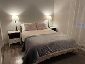 1 dormitorio con 1 cama grande y 2 mesitas de noche en Auk Nu, Cove View Alaskan Home, en Mendenhaven