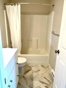 bagno bianco con servizi igienici e doccia di Auk Nu, Cove View Alaskan Home a Mendenhaven