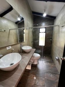 ein Badezimmer mit zwei Waschbecken, einem WC und einer Dusche in der Unterkunft CASA CAMPESTRE VILLA SANTANA in Villa de Leyva