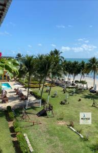 a park with a beach with palm trees and chairs at Apart Hotel Marinas Tamandaré in Tamandaré +37 photos