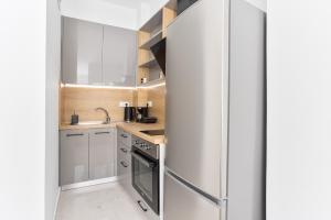 a small kitchen with white cabinets and a refrigerator at New Luxury Apartment in Downtown in Thessaloniki +21 photos