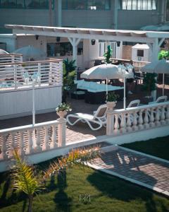 a balcony with chairs and umbrellas and a table at La Palazzina Bed & Breakfast in Porto Cesareo