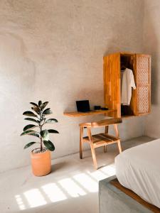 a bedroom with a desk and a table and a potted plant at Tukasa - Surfhouse Popoyo in Popoyo
