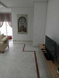 a living room with a television and a couch at appartement S+2, proche plage in Monastir