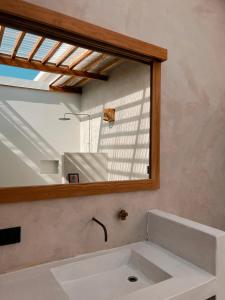 ein Badezimmer mit einem Spiegel über einem Waschbecken in der Unterkunft Tukasa - Surfhouse Popoyo in Popoyo