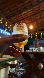 a person holding a glass of wine at Pousada Jardim de Pedras in Pancas