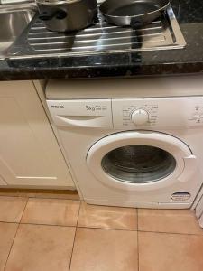 uma máquina de lavar roupa com um pote em cima em Fully equipped entire flat in Lewisham em Londres
