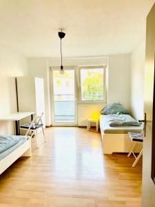 um quarto com duas camas e uma mesa e duas janelas em Ferienwohnung für 4 Personen, U-Bahn, Autobahn Nähe, Balkon em Nuremberga