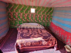 a small room with a bed in a tent at Mirdane Camp in Merzouga