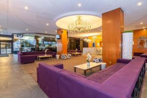 un vestíbulo con muebles de color púrpura y una lámpara de araña en Sandman Signature Edmonton Downtown Hotel, en Edmonton