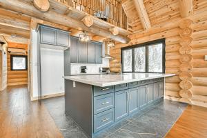 a kitchen with blue cabinets and a refrigerator at Le Chalet Enchanté in Saint-Donat-de-Montcalm