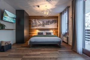 a bedroom with a bed and a chandelier at Diamante ampio monolocale stile chalet alpino in Passo del Tonale