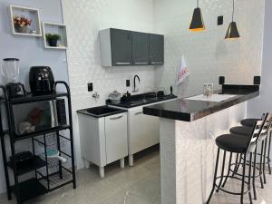 a kitchen with a counter and a sink and a microwave at Kitnets Cidade de Goiás-Go 02 in Goiás