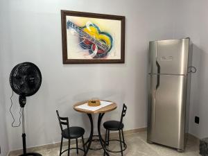 a kitchen with a table and a refrigerator at Kitnets Cidade de Goiás-Go 02 in Goiás