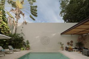 a swimming pool in a house with a palm tree at DECU DOWNTOWN in Mérida