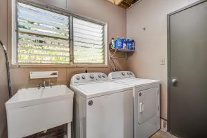 a laundry room with a sink and a washing machine at Ohanakupa Retreat #3 in Papaikou