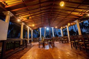 un ristorante con tavoli e sedie sulla spiaggia di Helios Beach Resort a Tangalle