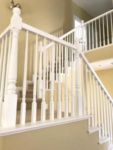 a white staircase with white railings in a house at Comfortable room in Riverside in Riverside