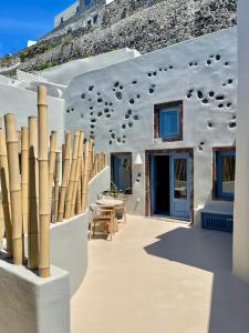 a white building with a table and chairs in front of it at Luna Santorini Suites in Pirgos