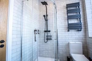 a bathroom with a shower and a toilet in it at VIP 3BR Grade2 Luxurious Industrial House with WOOD FIRE, Electric blinds and big Cast iron Windows in the heart of the JQ in Birmingham