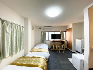 Una habitación de hotel con dos camas y un escritorio. en Asakusa正和House, en Tokio