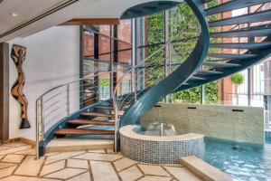 a spiral staircase in a building with a swimming pool at Azalaï Hôtel Dakar in Dakar