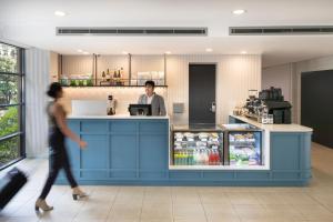 a man standing at a counter in a restaurant at Mercure Sydney Manly Warringah in Sydney