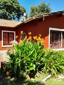 un jardín frente a una casa con flores en LA CALANDRIA en Sierra de los Padres