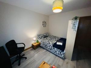 um pequeno quarto com uma cama e uma cadeira em Bedroom + Bathroom D8 em Dublin