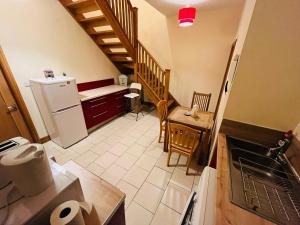 eine Küche mit einer Treppe, einem Tisch und einem Kühlschrank in der Unterkunft Bedroom + Bathroom D8 in Dublin