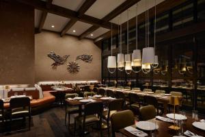 a dining room with tables and chairs and chandeliers at Renaissance New York Chelsea Hotel in New York