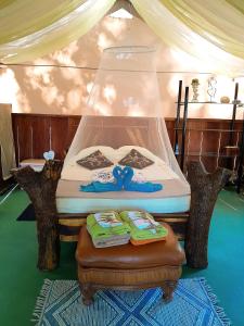 a bed with a canopy and a table with towels at Fully Furnished FAMILY JUNGLE TENT, Latino Glamping Paquera in Paquera