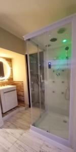 y baño con ducha de cristal y lavabo. en AYRES SUITE en Villa Carlos Paz