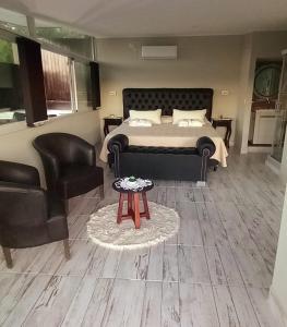 AYRES SUITE في فيلا كارلوس باز: غرفة نوم بسرير واريكة وطاولة