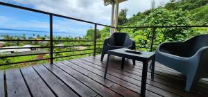 Un balcón con sillas y una mesa con vistas. en Bungalow Tipanier - Vue parfaite en Tevaitoa