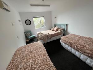 1 dormitorio con 2 camas y ventana en Kaikoura Seaside lodge, en Kaikoura