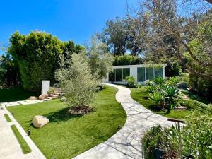 a garden with a walkway in front of a house at The Glass House Montecito in Santa Barbara