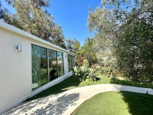 a white house with large windows and a yard at The Glass House Montecito in Santa Barbara +3 photos
