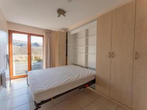 a bedroom with a bed and a large window at Plaza A1A02 located on the dunes in Oostduinkerke